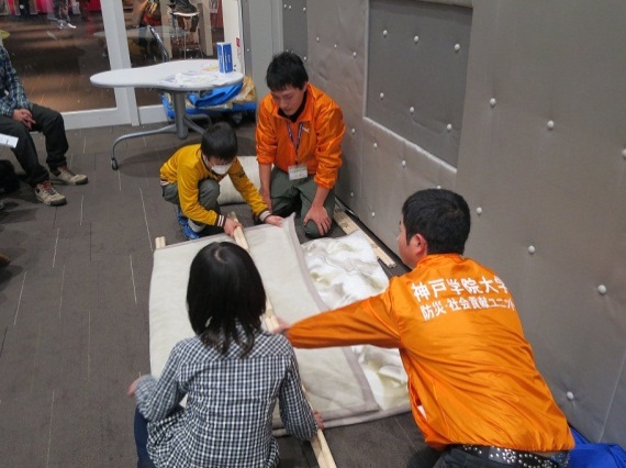 毛布と棒を使って担架の作り方を説明する大西さんと大智さん