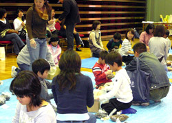 学生スタッフに教えてもらいながら、親子でダンボールコンポスト作り
