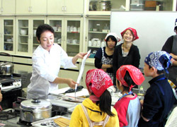 魚のさばき方を実演する、サークル「神戸学院キッチン」の吉川美子さん