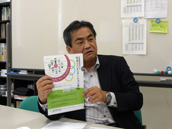ＣＬＣ主催のセミナーの内容を印字したクリアファイルを手に、本学で開催する意義を語る藤井教授