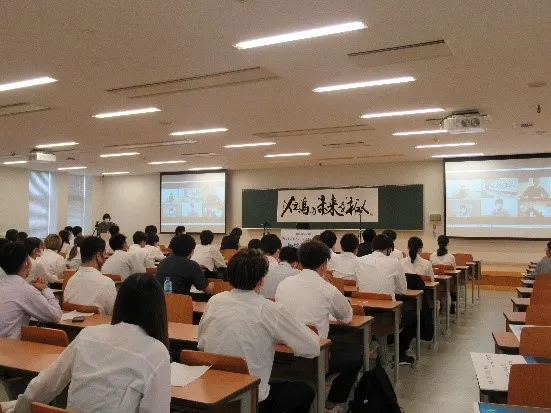 ゲストは、対面とオンラインで参加。「但馬の未来を拓く」の題字は、書家の川尾朋子さん