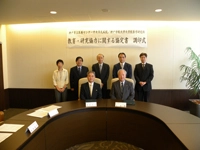 調印式を終え、記念撮影する岡田学長(前列左)ら関係者