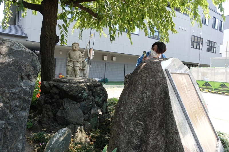 京都市学校歴史博物館で、旧開智小学校の設立90周年を記念した像を見つけて撮影する井上さん