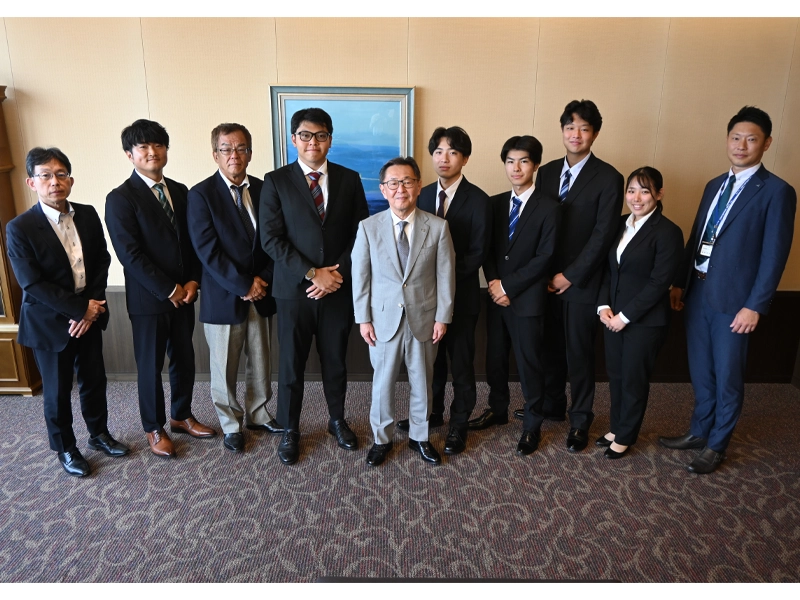 備酒学長（右から６人目）、高山大学事務局長（左端）と記念撮影する体育会洋弓部の指導者と学生
