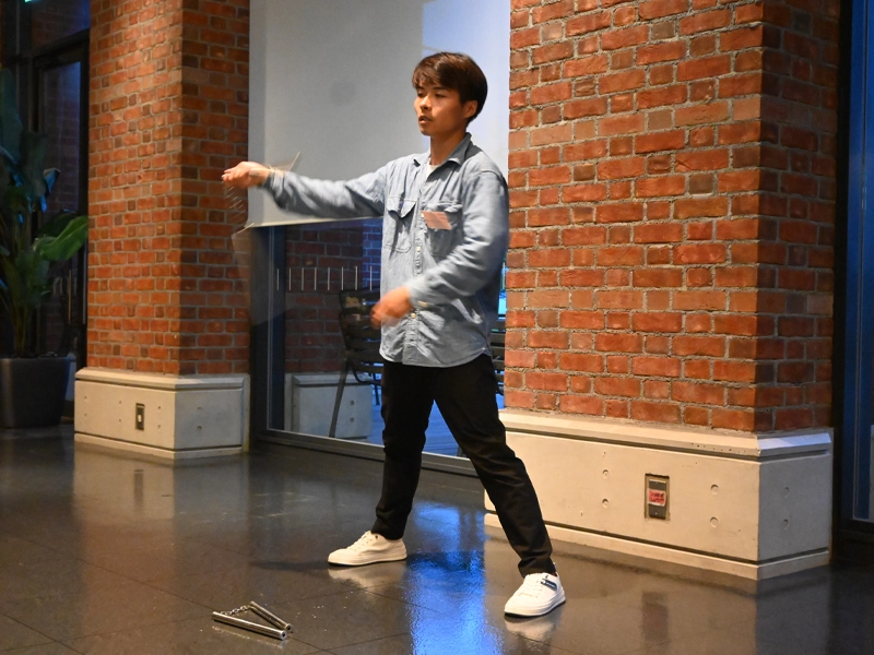 ヌンチャク芸を披露する留学生会のリュウ ケンコウ会長