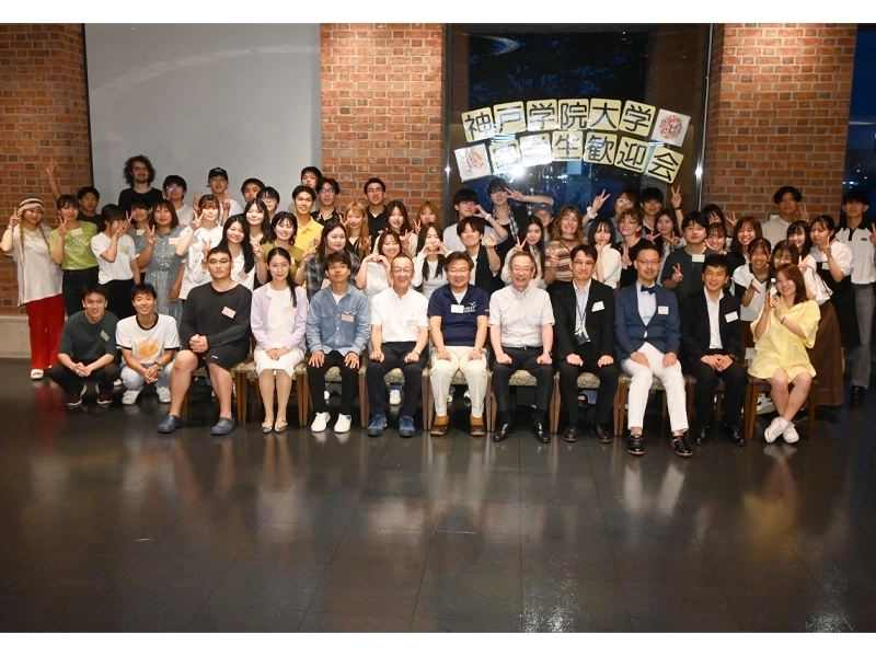 記念撮影する新入留学生歓迎会の参加者ら