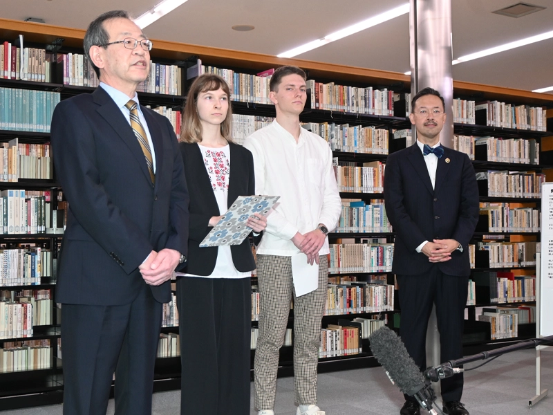 オープニングセレモニーであいさつする中村学長(左端)、マリヤさんとマクシムさん、司会の岡部所長(右端)