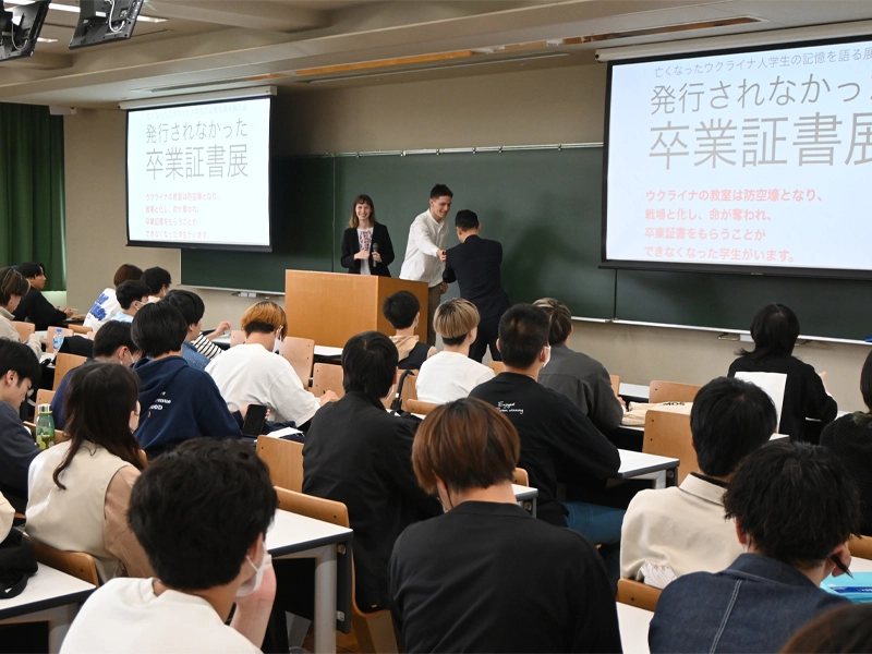 展示を企画した2人の話を聞く授業に出席した経済学部の学生たち