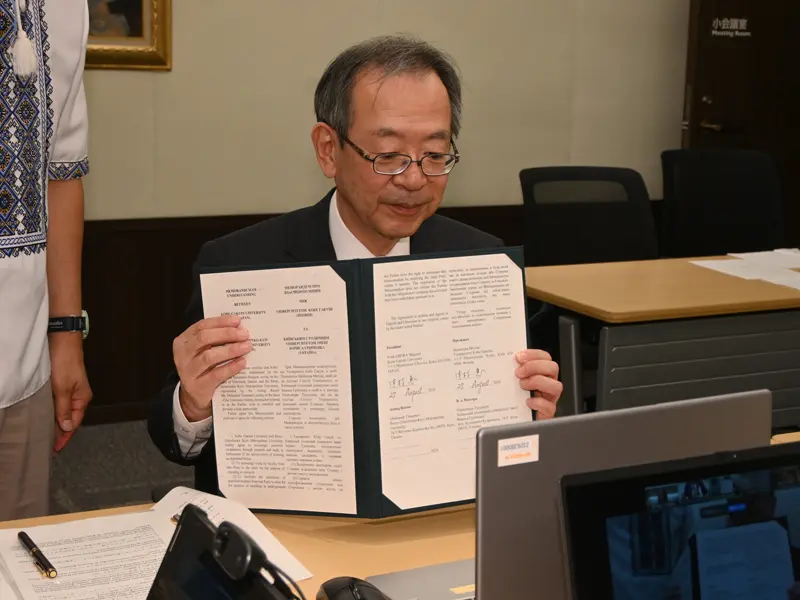 署名した協定書を相手方に示す中村学長