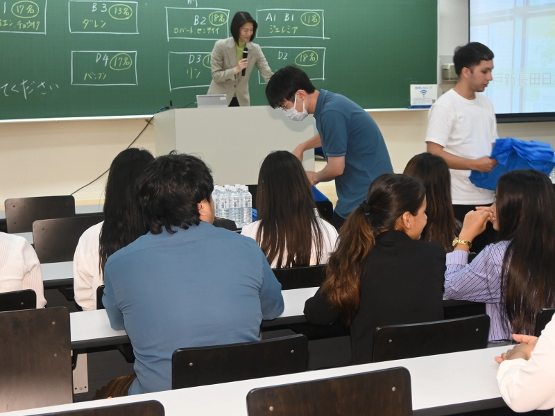 プレゼントのバッグを配る本学の先輩留学生