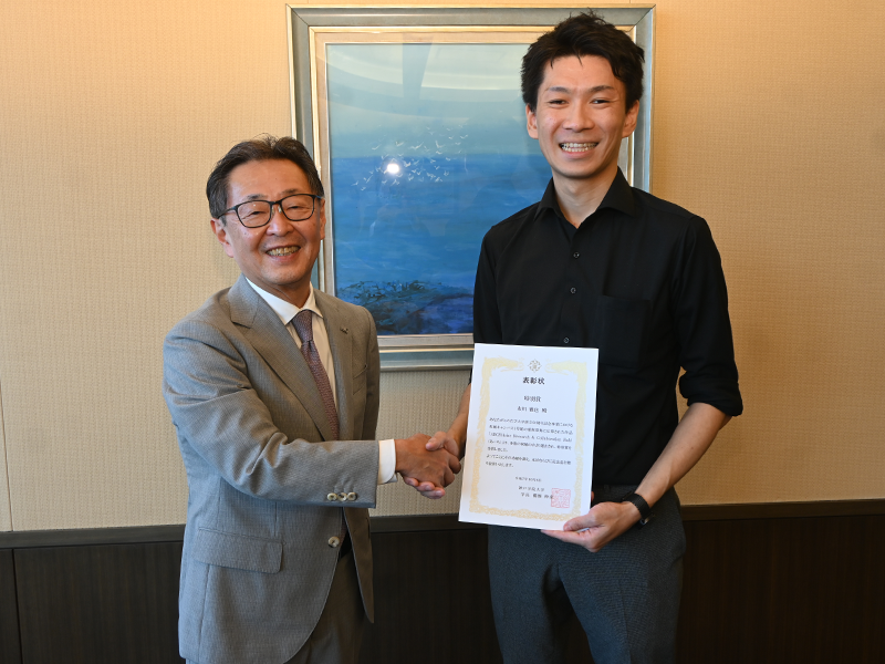 備酒学長から表彰状を渡され笑顔の市川さん(右)