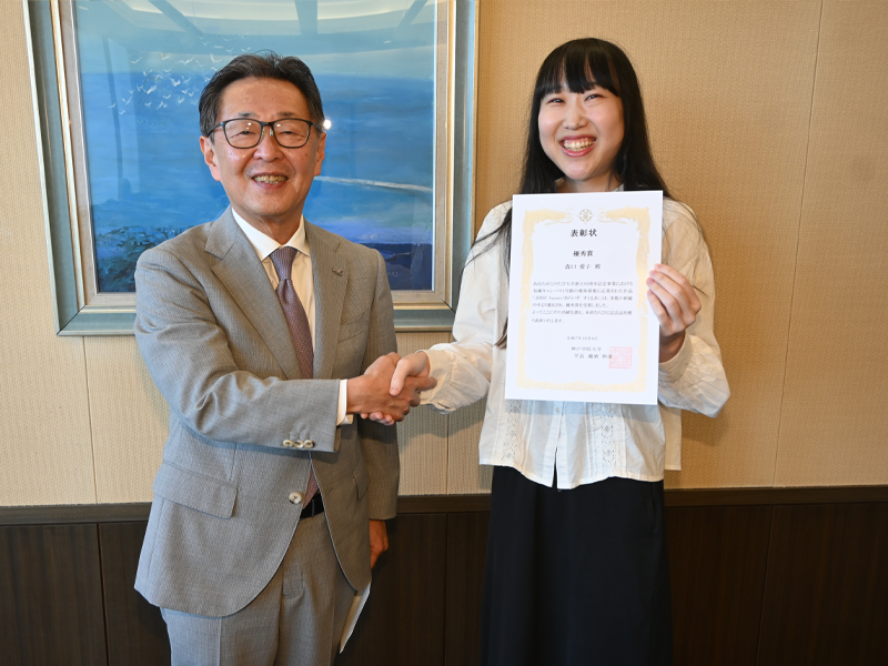 備酒学長から表彰状を渡され笑顔の森口さん(右)