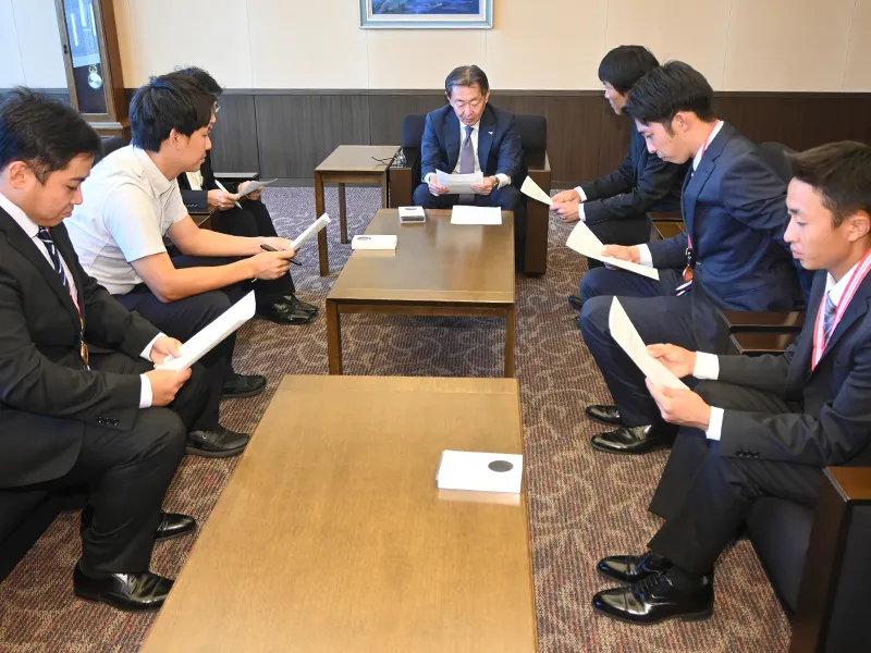 報告するソフトボール部員と指導者