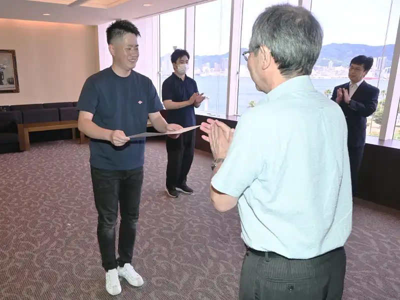 中村学長からの表彰状を受け取る最優秀賞の坂本さん