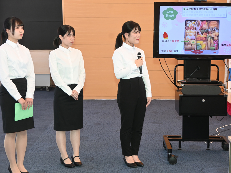 おせちに入っている料理の説明をする学生たち
