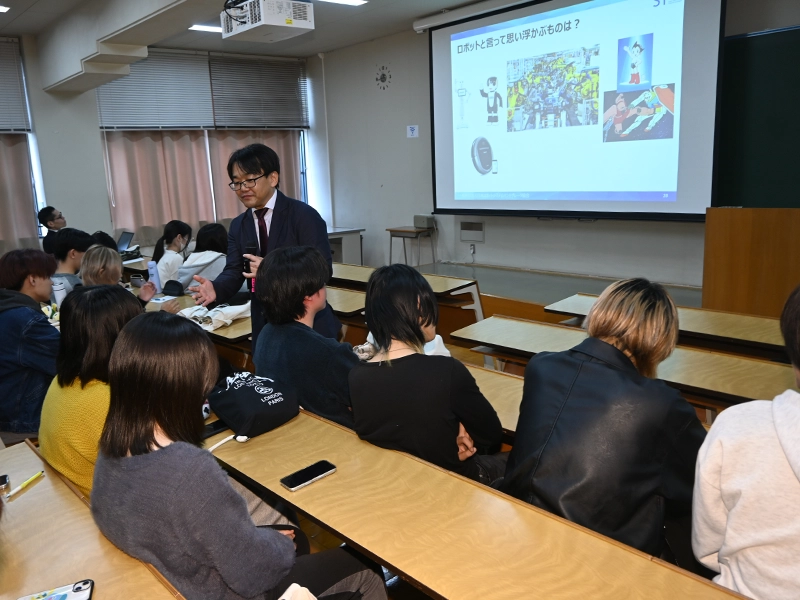 学生の間に入って関心を促す田口さん