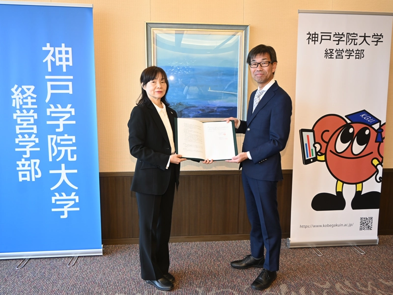 包括連携協定を締結した経営学部の辻学部長(左)と株式会社丸井の亀山取締役