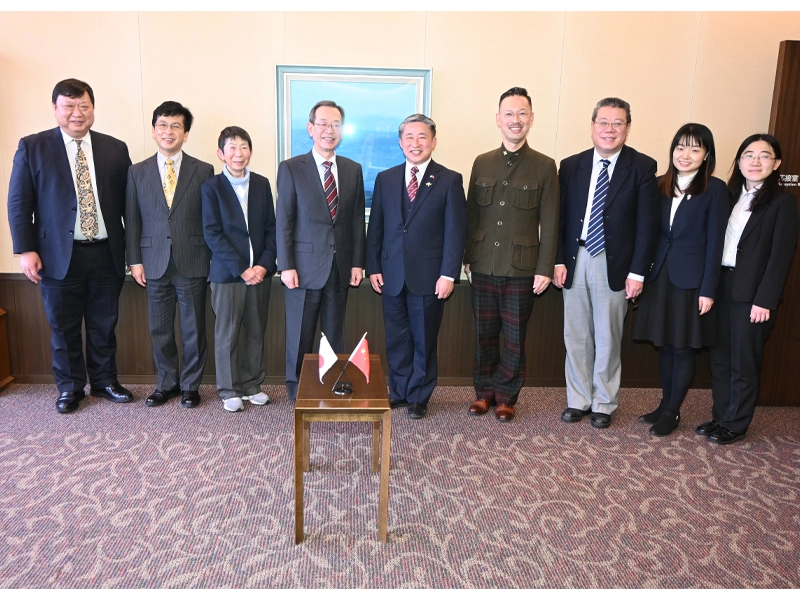 中村学長らと記念撮影する薛総領事(中央)、ニェ・ズイリン領事(右から3人目)ら外交官
