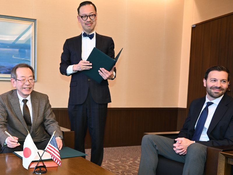 岡部所長(中央)の立ち合いで署名する中村学長(左)とグアラシオ教授