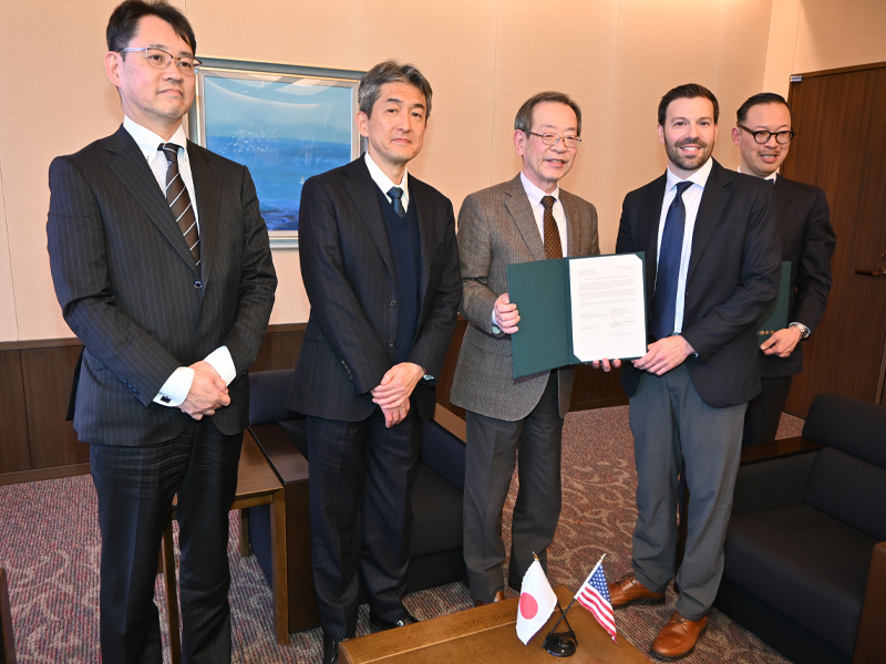 調印した協定更新の確認書を持つ中村学長(中央)とグアラシオ教授(右隣)