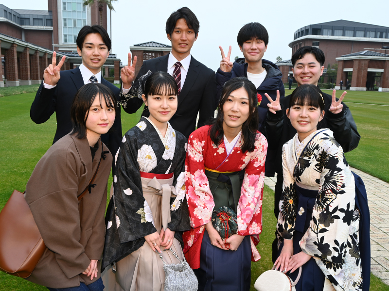 キャンパスグリーンで記念撮影する卒業生