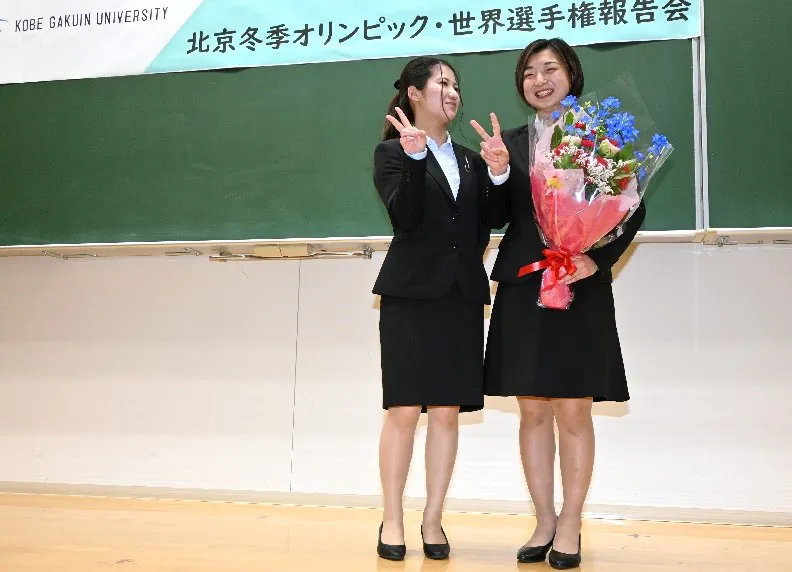 体育会本部の中谷会長(左)から花束を贈られ笑顔の坂本さん