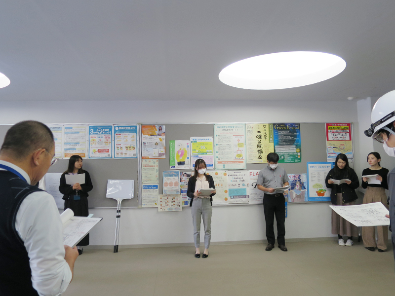有瀬キャンパスで避難誘導訓練の説明を聞く自衛消防組織のメンバーら