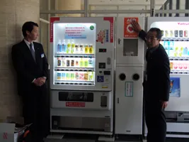 AED付自動販売機を設置した兵庫ヤクルト販売株式会社の田淵さん(右)と、AEDを取り扱う日本電工関西株式会社の萩田さん(左)