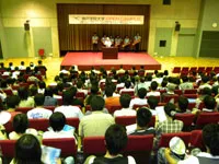マナビーホールで開かれたオープニングセレモニーで約400人の参加者を前に開会宣言する岡田学長