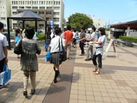 オープンキャンパスの参加者に刷り上ったばかりの神院新聞を配布する新聞会のメンバー