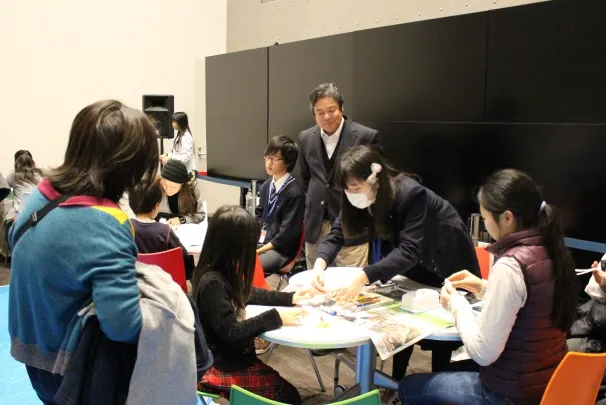 バランス紙とんぼづくりを説明する附属高等学校の洞七々海さん