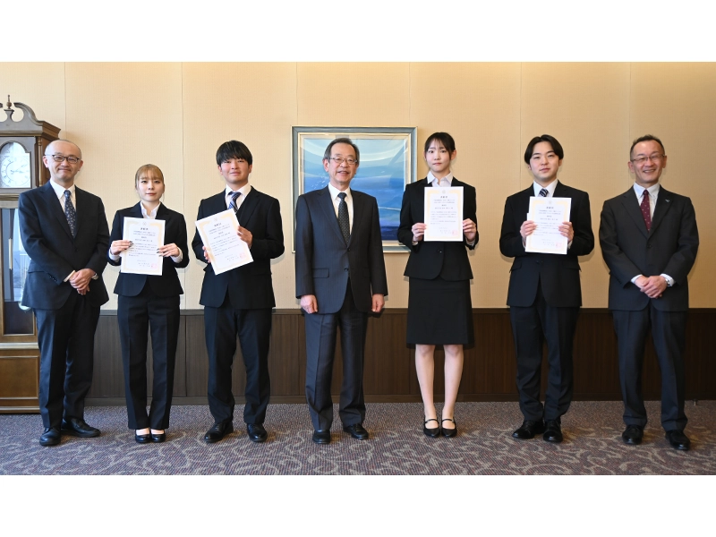 表彰式で記念撮影する(左から)矢嶋学長補佐、河野桜子さん、大西凜央さん、中村学長、岡本愛衣子さん、横山悠大さん、生田副学長