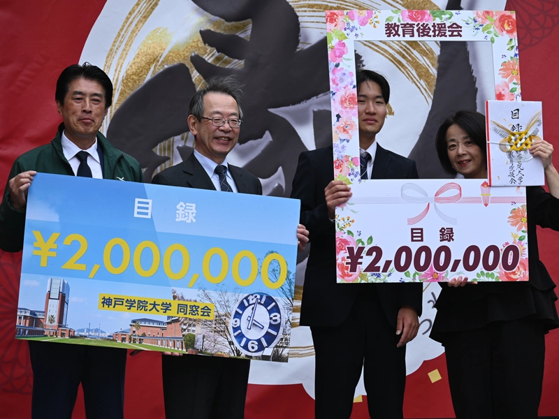 同窓会と教育後援会からの多額の運営支援金の目録を受領して笑顔の牛尾会長(右から2人目)と中村学長(左隣)
