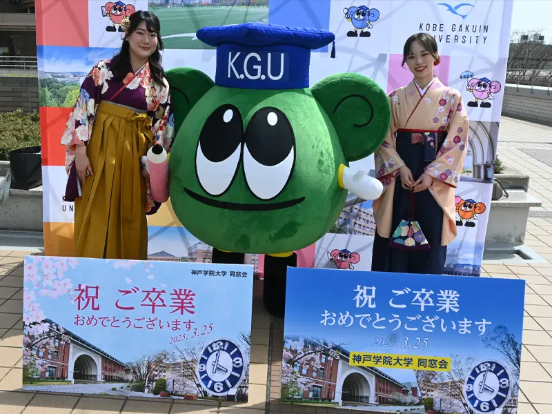 同窓会が準備したマナビーの着ぐるみと記念撮影する卒業生