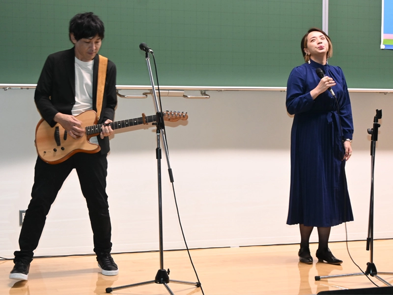 プロジェクトのテーマ曲を披露する山田明義さん（左）とアヤヲさん