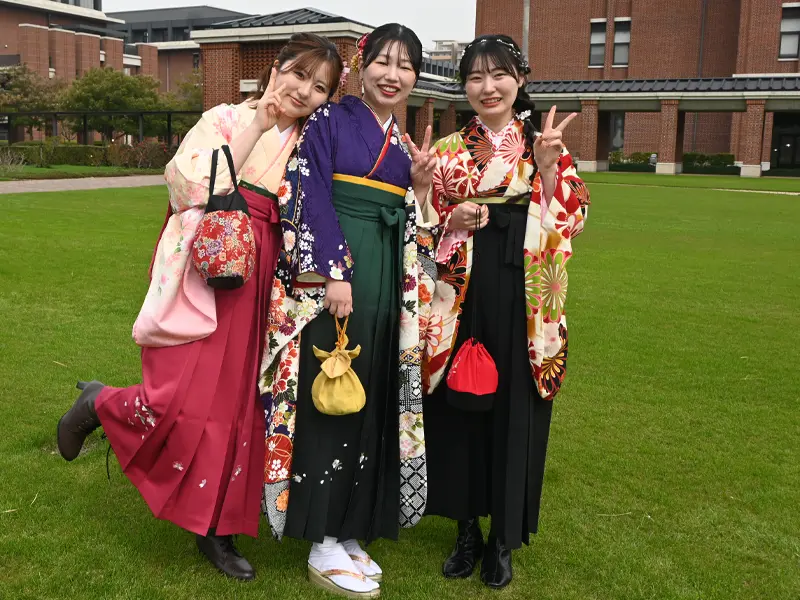 キャンパス・グリーンで記念撮影する卒業生