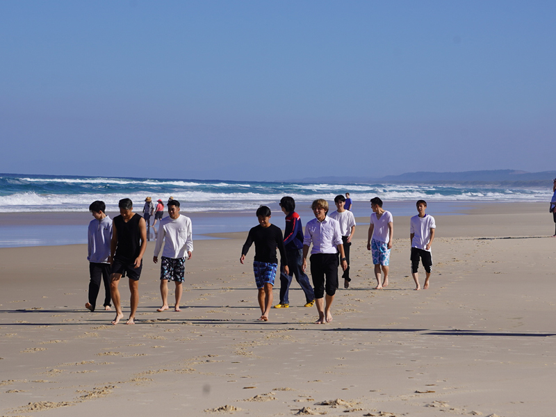 砂浜を歩く学生たち