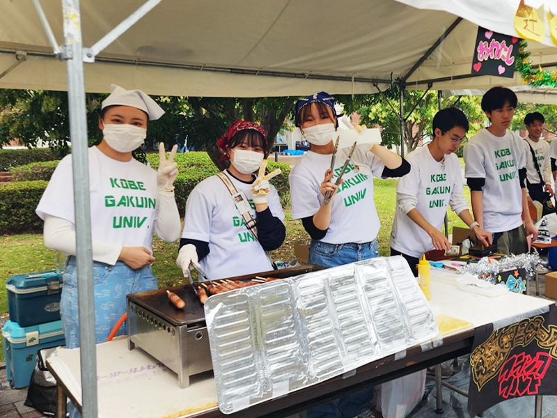 経営学部・辻ゼミの模擬店でポーズを取る学生