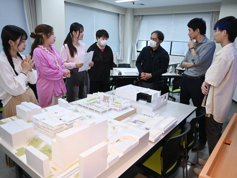 模型を囲んで話し合う学生たち