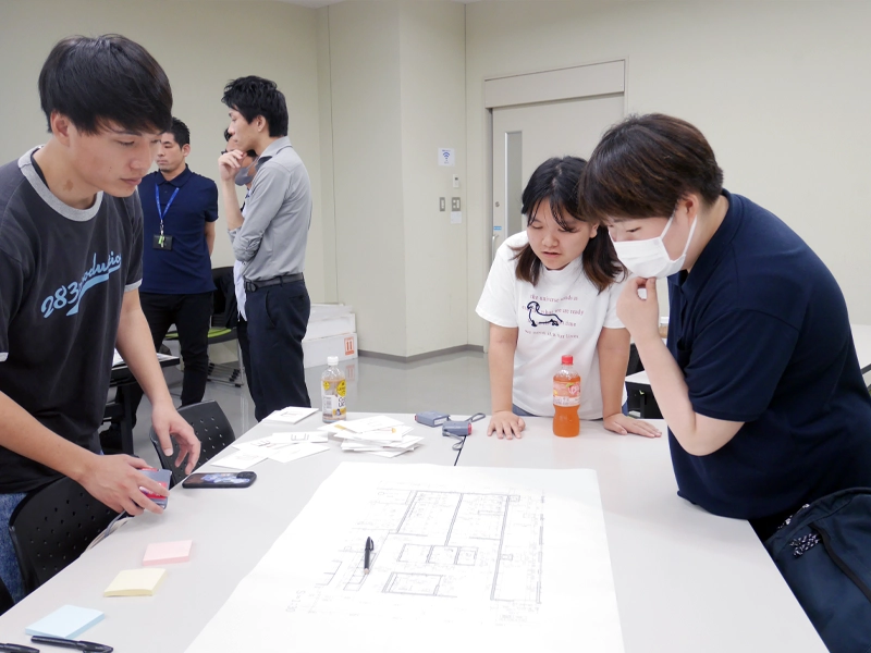 設計図を見ながら話し合う学生