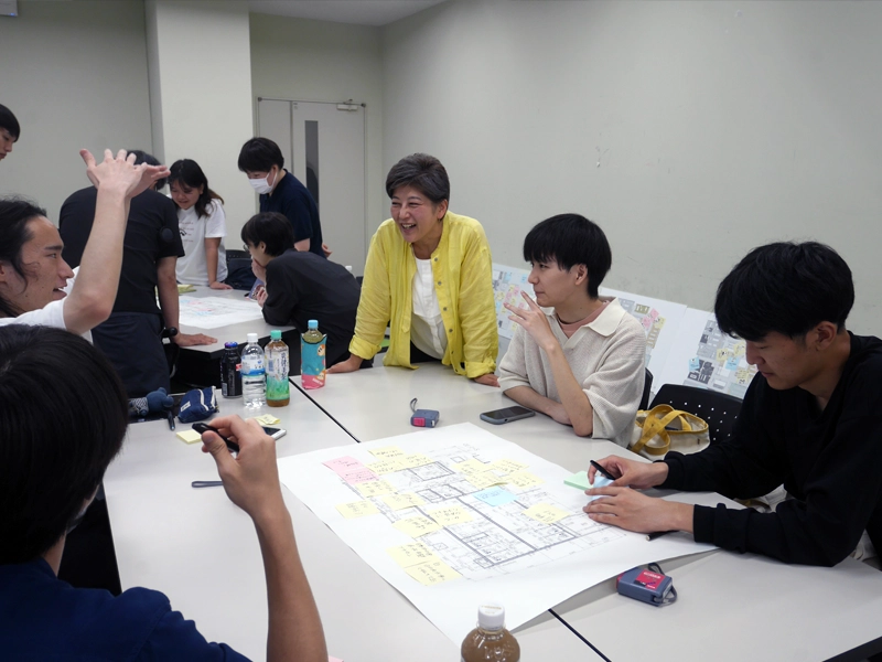 設計図を見ながら話し合う糟谷教授と学生