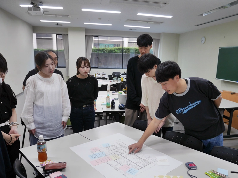 設計図を見ながら話し合う学生