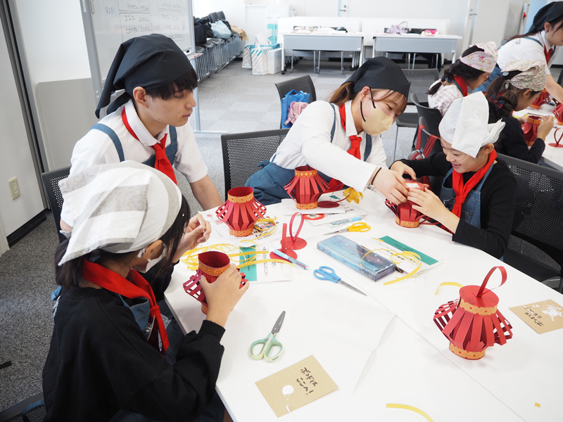 提灯の作り方を説明する学生スタッフ