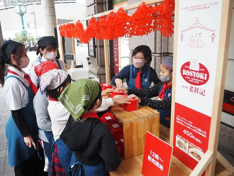 開店準備を行うこども達と木暮准教授