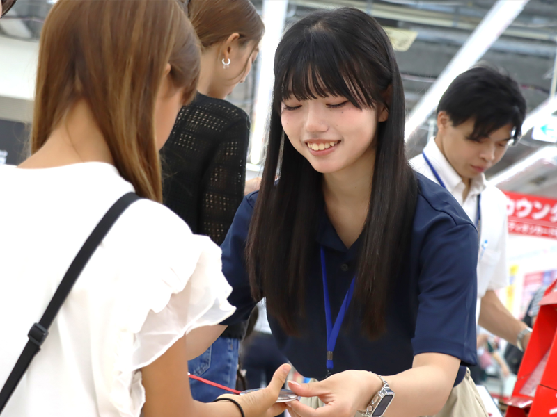 手作りの缶バッジを手渡す井ノ口さん