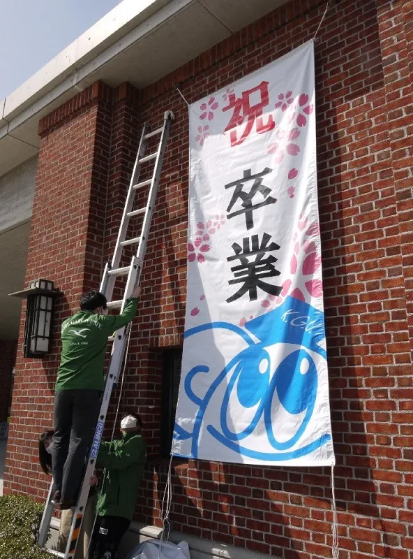 大型のはしごを使い、バナーも「祝卒業」に取り換え