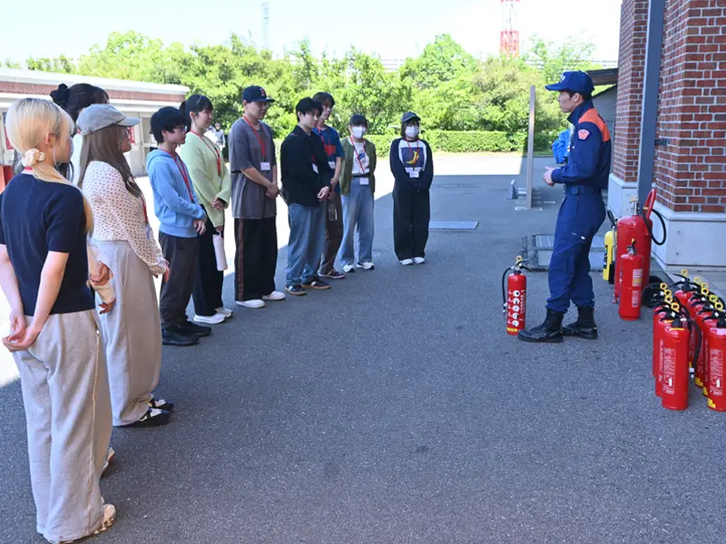 さまざまな消火器についての説明を聞く薬学部生