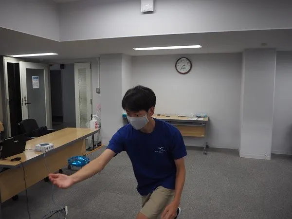 ドローンの飛ばし方を説明する学生スタッフ