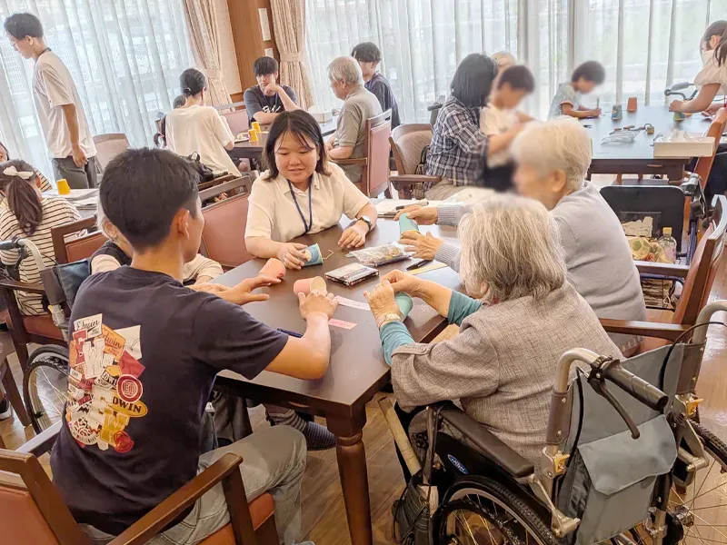 七夕の短冊に願い事を書く参加者ら