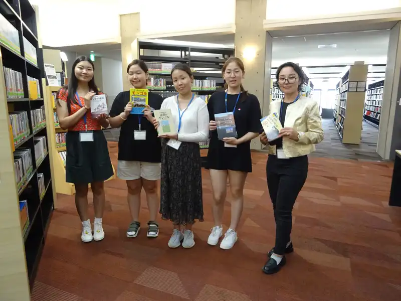 図書館でモンゴルに関する本を手にする中学生たち(右端は教員のマイダルマさん)
